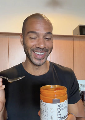 Man holding a jar of Celtara liver health supplement against a neutral background.