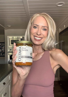 Woman holding a jar of Celtara liver health supplement against a neutral background.