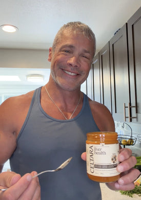 Man holding a jar of Celtara liver health supplement against a neutral background.