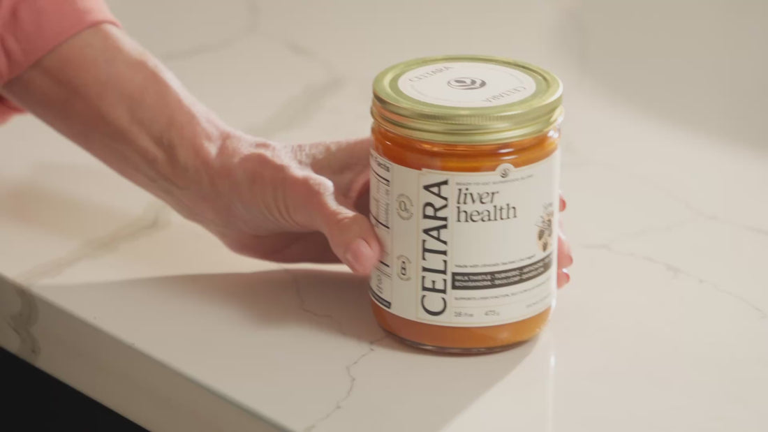 Hand placing a jar of Celtara liver health supplement on a countertop.